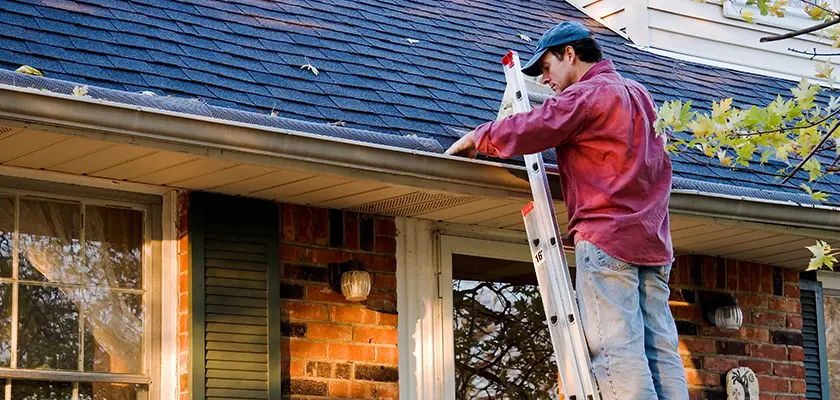 Man inspecting gutters to determine need for replacement.