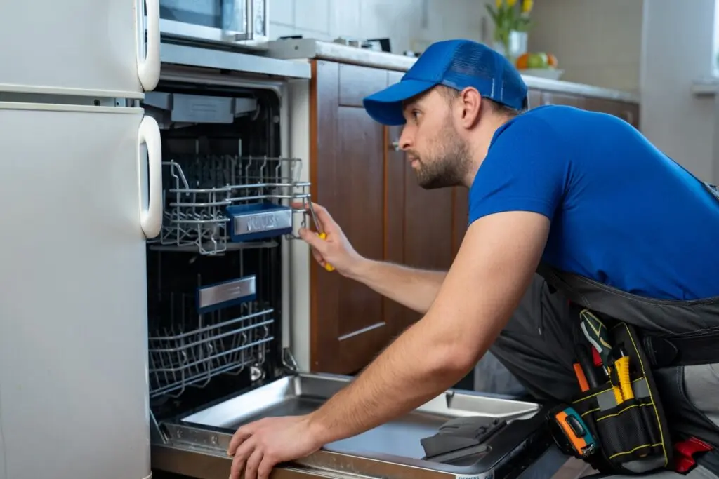 Repairman fixing problems with a broken dishwasher.